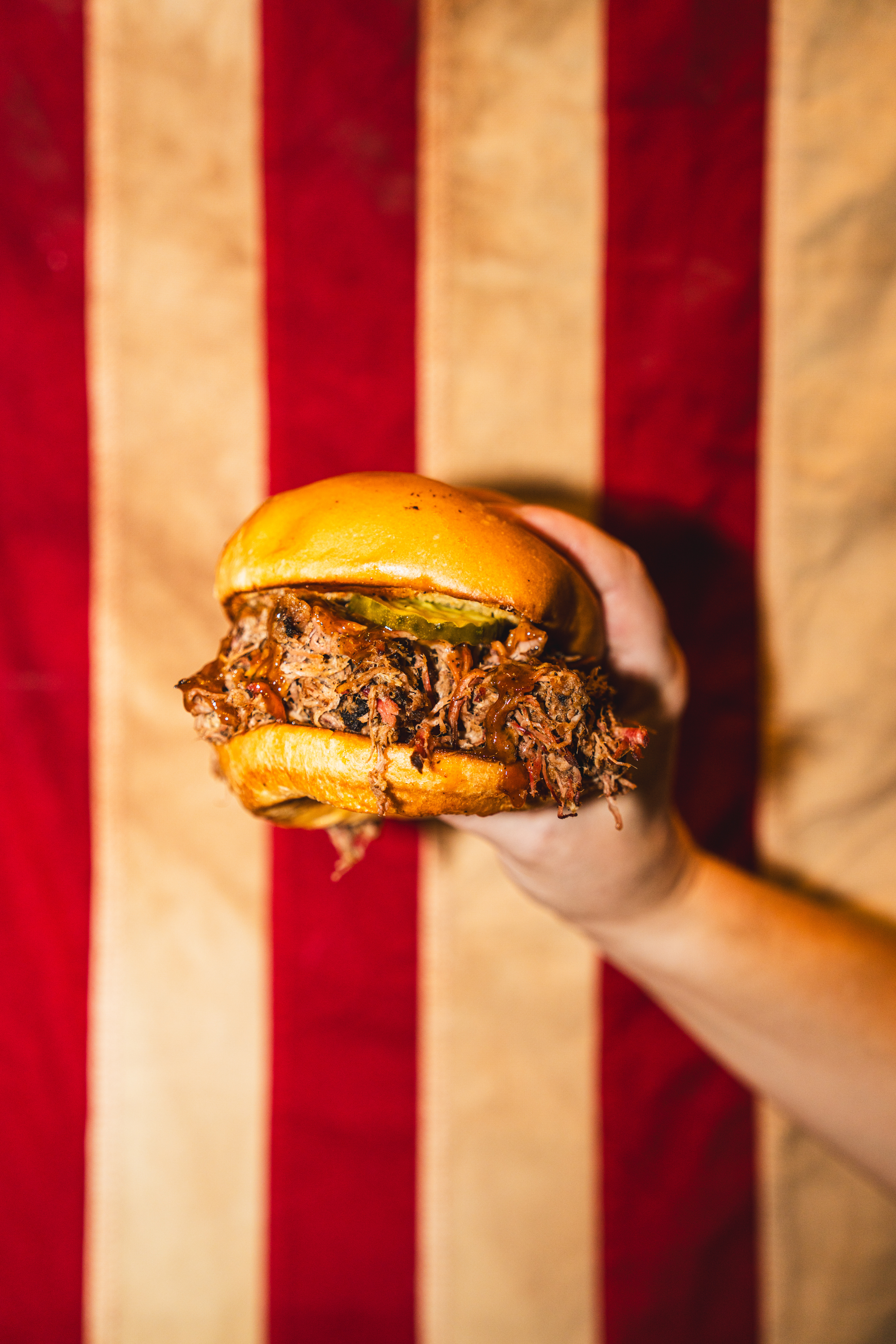 Edley's BBQ owner holding a BBQ sandwich